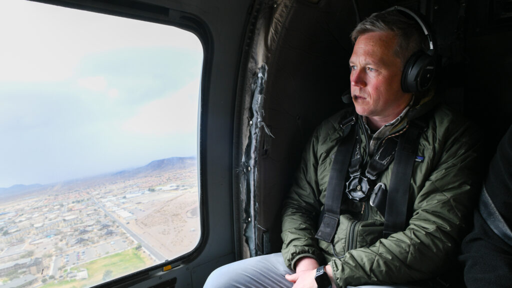 Secretary of the Army in helicopter looking out window.