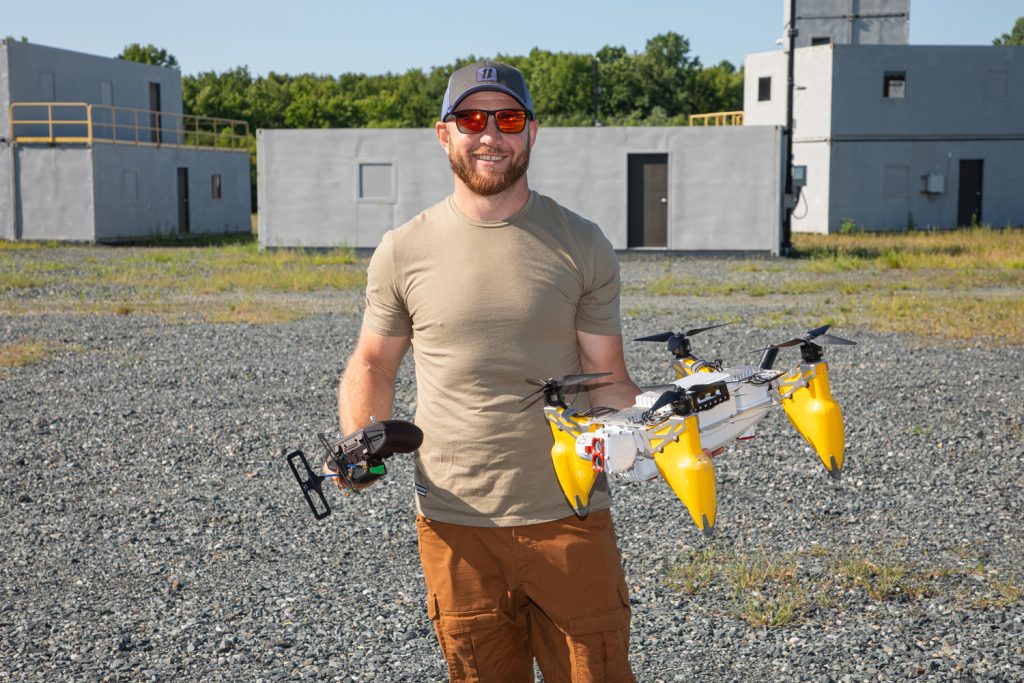Man holding drone in open lot